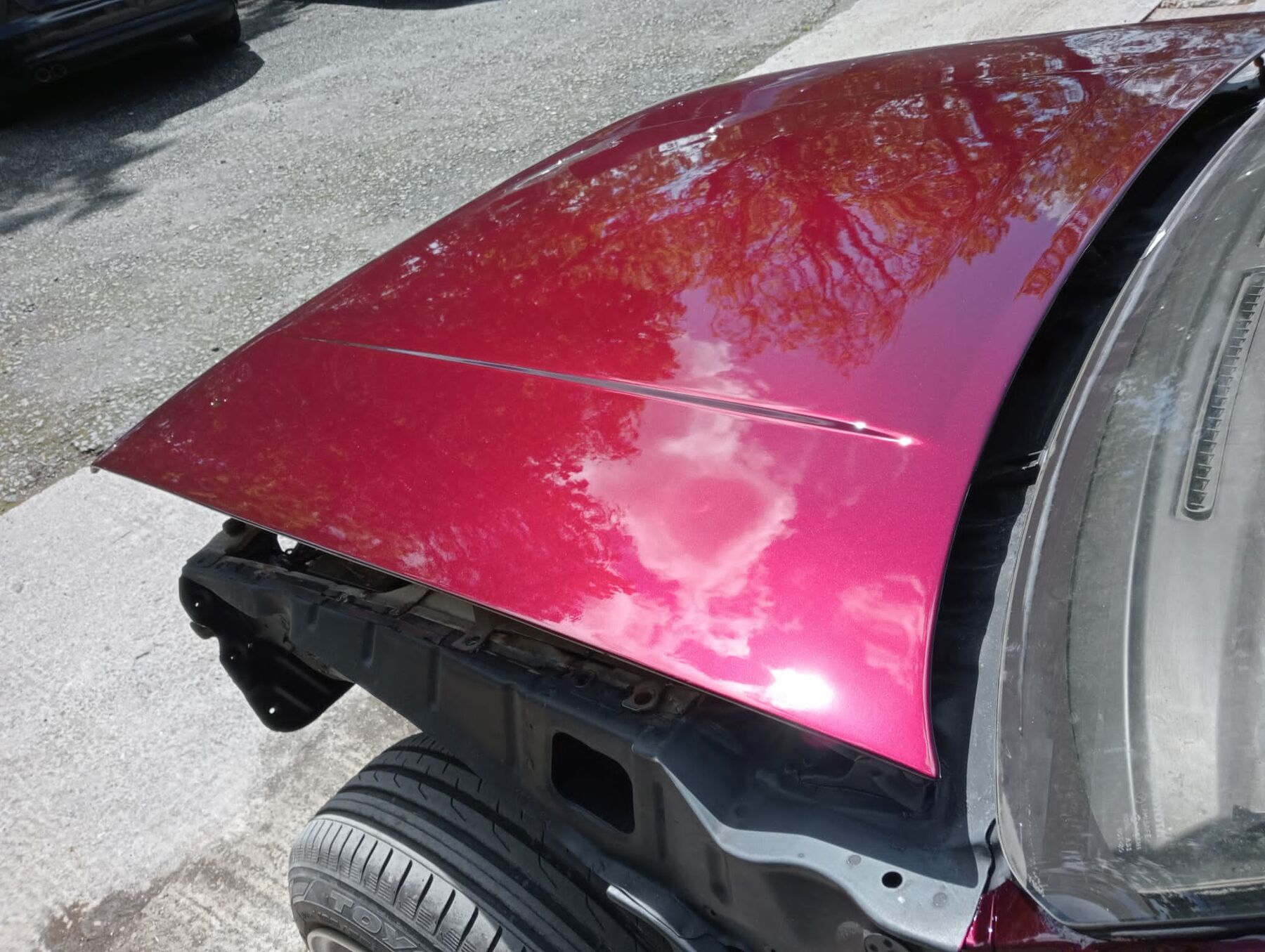 Freshly painted metallic red wing reflecting the sky, work by Willis's Garage Bodyshop